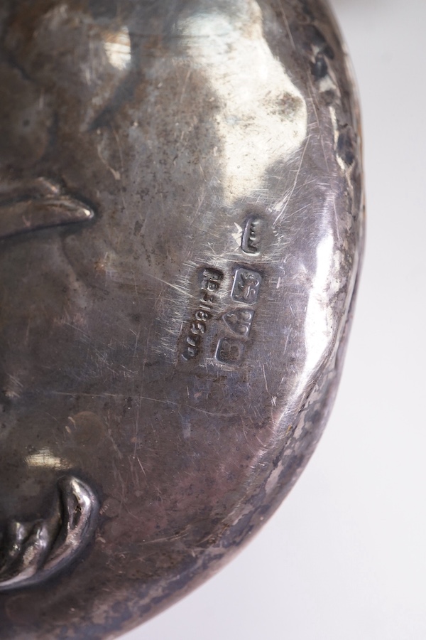 An Edwardian silver mounted hand mirror with Reynold's Angels decoration, William Neale Ltd, Chester, 1902, 26.3cm, together with a later silver mounted cut glass preserve jar and spoon. Condition - poor to fair